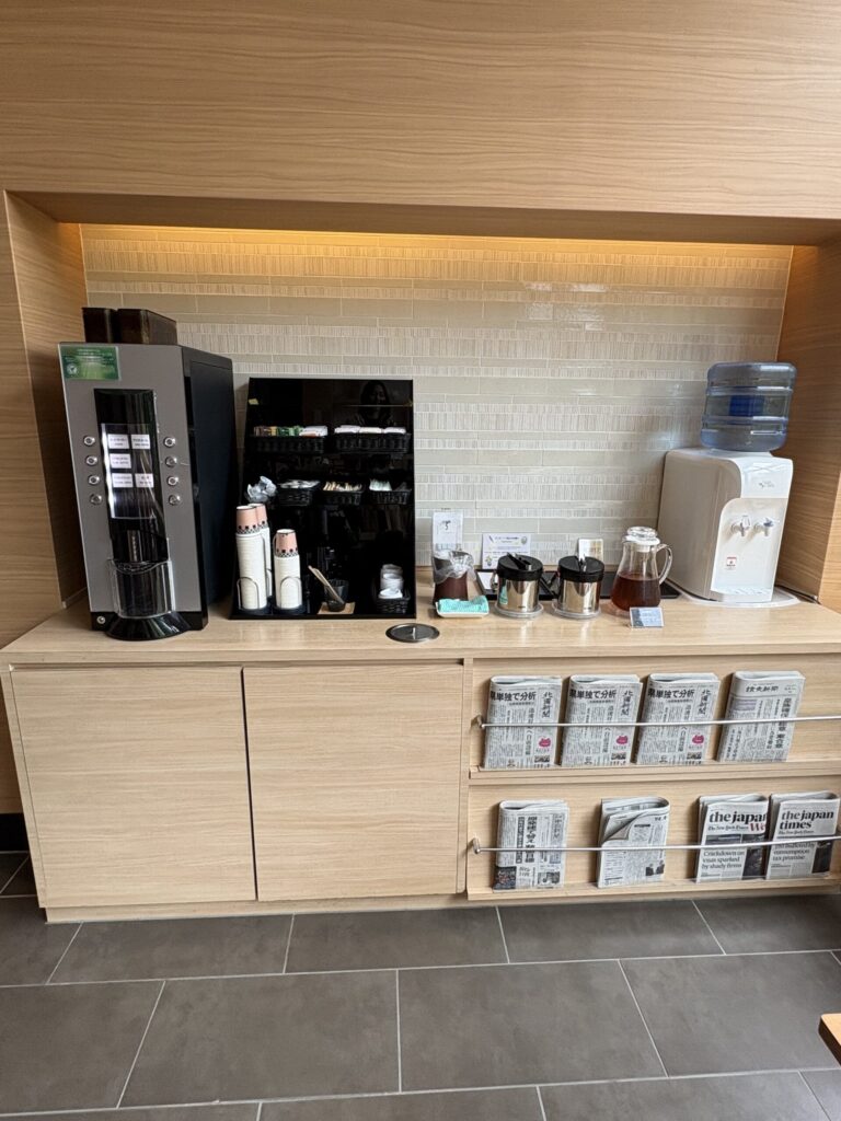 ラウンジの無料ドリンクコーナー（コーヒーマシンと新聞）