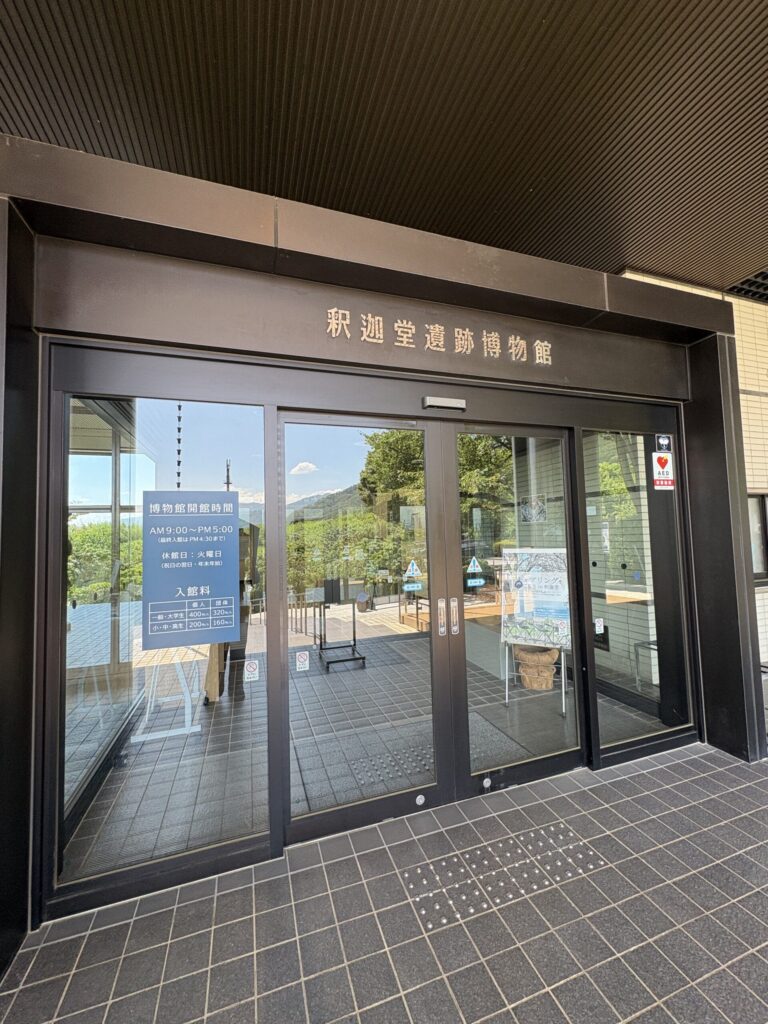 釈迦堂遺跡博物館の入口。ガラスの自動ドアの上に「釈迦堂遺跡博物館」の館名表示