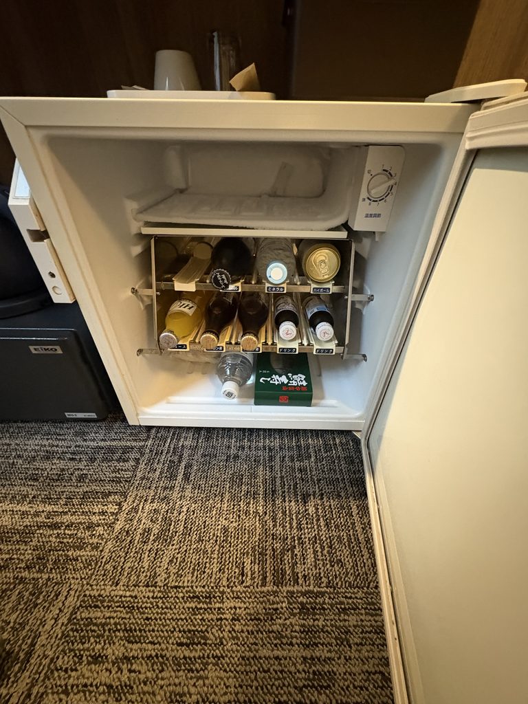 客室の冷蔵庫。備え付けの飲み物が並び、空いているのは下の一段だけ